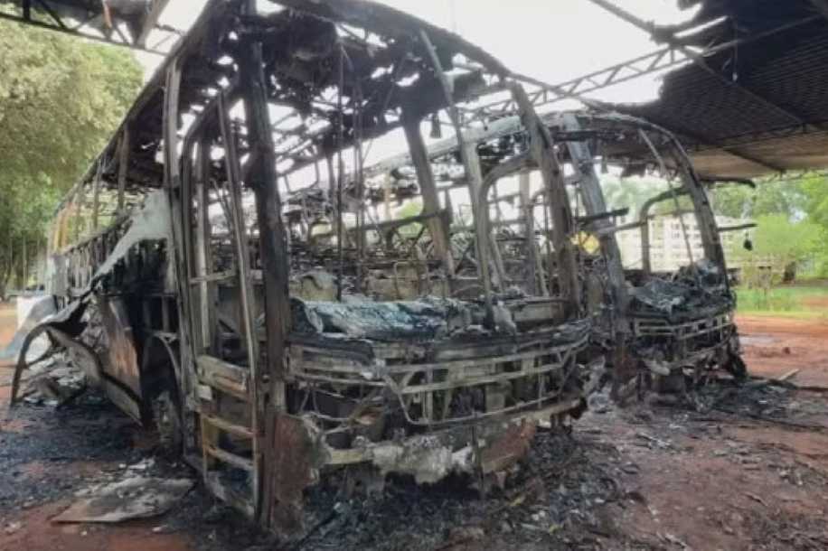 Polícia investiga incêndio criminoso em ônibus após câmera flagrar homem pulando portão com galão