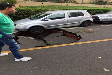 Asfalto cede e carro estacionado quase cai em cratera aberta em rua de Rio Preto